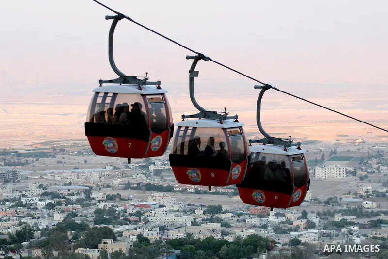 Tourists tour the historic sites of Jericho in cable cars during celebrations on the third day of the Eid al-Fitr holiday, which marks the end of the holy fasting month of Ramadan in the West Bank city of Jericho on Sept...