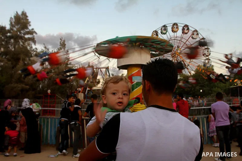 Palestinian children enjoy a ride at an amusement park on the third day of the Eid al-Fitr holiday, which marks the end of the holy fasting month of Ramadan in Gaza city on Sept. 1,2011. Photo by Ashraf Amra