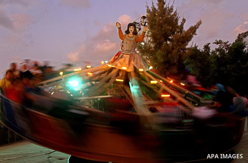 Palestinian children enjoy a ride at an amusement park on the third day of the Eid al-Fitr holiday, which marks the end of the holy fasting month of Ramadan in Gaza city on Sept. 1,2011. Photo by Ashraf Amra