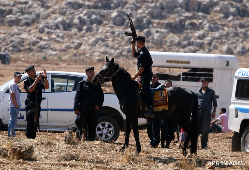 Palestinian security forces take pictures during a horse race in the West Bank village of Abu Falah, near the town of Ramallah ,on 02 September 2011. Some 60 horses in different heats participated in races through the da...