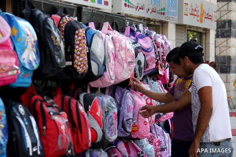 Palestinians walk past school bags as vendors display them in the preparation of new school year in a market in the West Bank city of Nablus on Sept. 03, 2011. The Palestinian students in the West Bank and Gaza Strip wil...