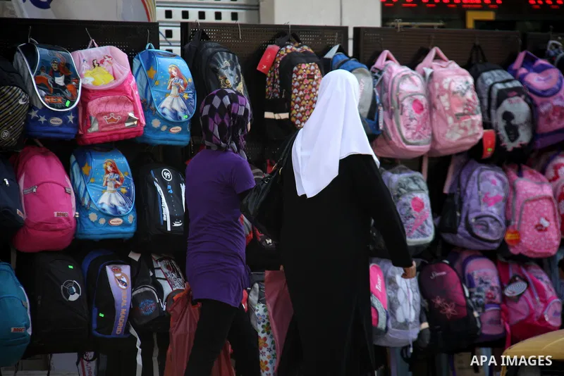 Palestinians walk past school bags as vendors display them in the preparation of new school year in a market in the West Bank city of Nablus on Sept. 03, 2011. The Palestinian students in the West Bank and Gaza Strip wil...