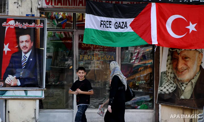 Palestinians walk past a poster of the Turkish Prime Minister Recep Tayyip Erdogan, the Arabic written on the poster "Palestine people love you", in Gaza city on Sep 3,2011. Turkey said Friday it was expelling the Israel...