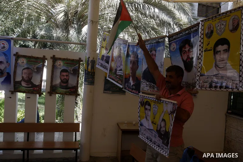 A Palestinian man holds pictures of his prisoned relatives in Israeli jails as they gather in a weekly activity calling for their liberty at the Red Cross headquarters in Gaza City onSep. 5, 2011. About 7000 prisoners ar...