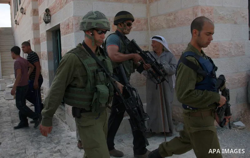 Israeli soldiers walk next to a mosque torched and vandalized by arsonists in the West Bank village of Qusra, near Nablus, Monday, Sept. 5, 2011. Arsonists tossed two tires into the first floor study hall of a new mosque...