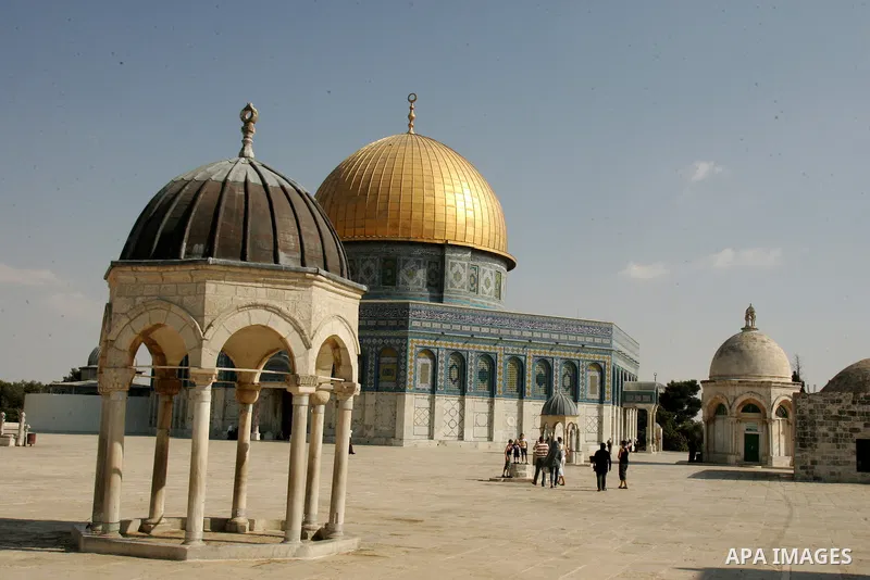 Palestinians walk in front of the Dome of the Rock at the Al-Aqsa mosque compound in Jerusalem's old city on Sep. 5,2011. Photo by Mahfouz Abu Turk