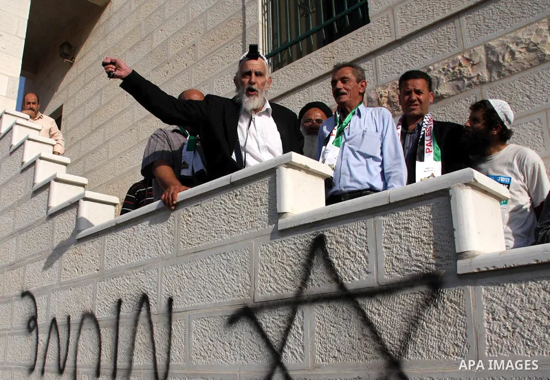 Jewish rabbi Menachem Froman leads a reconciliation visit of Jewish settlers to the West Bank village of Qusra, a day after the local mosque was vandalized, Tuesday, Sept. 6, 2011. The mosque was torched Monday after Isr...