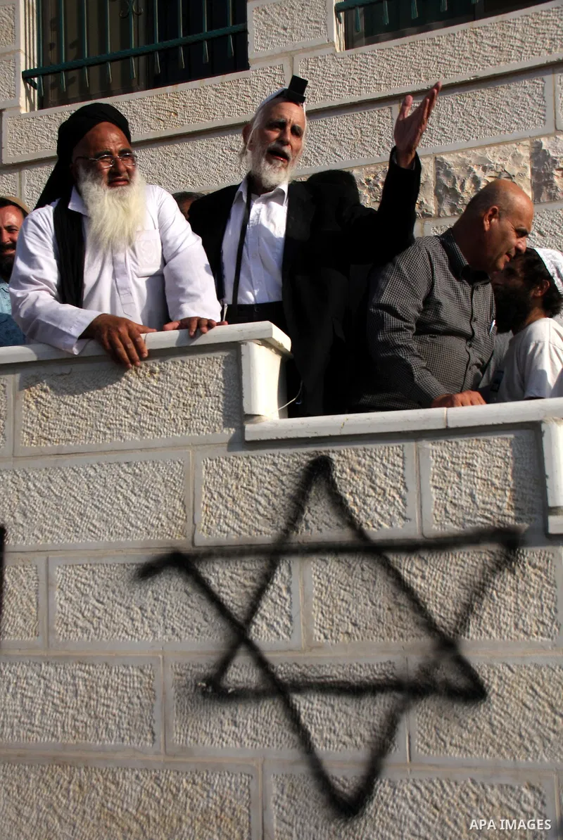 Jewish rabbi Menachem Froman leads a reconciliation visit of Jewish settlers to the West Bank village of Qusra, a day after the local mosque was vandalized, Tuesday, Sept. 6, 2011. The mosque was torched Monday after Isr...