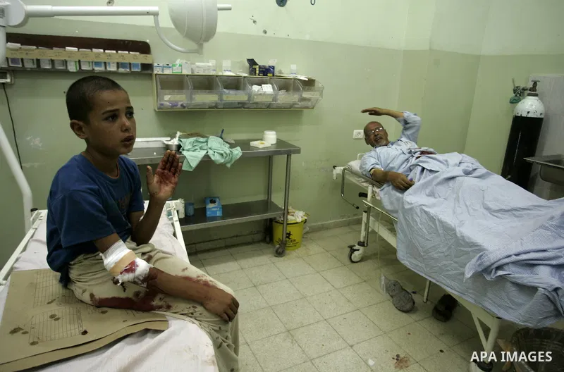 A wounded Palestinian father and his son receive medical care on September 6, 2011 at a hospital in Khan Yunis, following an Israeli air strike east of the central Gaza Strip city in which a Palestinian militant was kill...