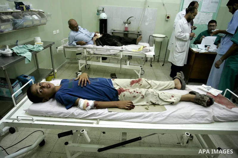 A wounded Palestinian father and his son receive medical care on September 6, 2011 at a hospital in Khan Yunis, following an Israeli air strike east of the central Gaza Strip city in which a Palestinian militant was kill...