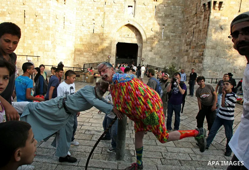 A Spanish clown demonstrates his skills in front of Palestinian children at the market near Damscus gate in Jerusalem's old city on Sep. 6,2011. Photo by Mahfouz Abu Turk