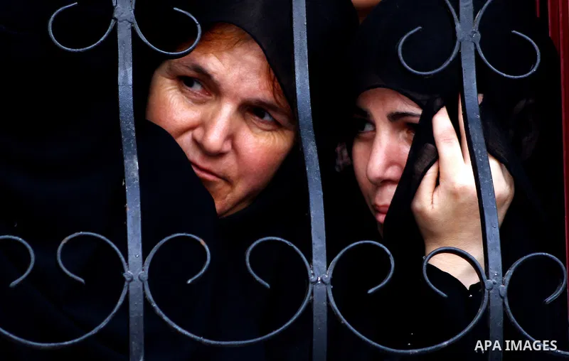 Palestinian women look through a window at the funeral procession of Popular Resistance Committees (PRC) member Khaled Sahmud in the town of Khan Yunis in the southern Gaza Strip on September 7, 2011 a day after he was k...