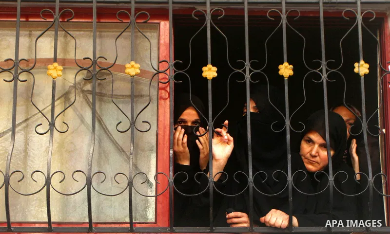 Palestinian women look through a window at the funeral procession of Popular Resistance Committees (PRC) member Khaled Sahmud in the town of Khan Yunis in the southern Gaza Strip on September 7, 2011 a day after he was k...