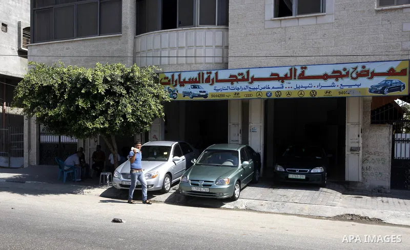 A Palestinian man walks near cars, at a showroom in Gaza City on Sep. 7, 2011. while Israel stop to enter cars into Gaza Strip again after it allowed to enter them as a part of a new strategy to increase Gaza blockade. P...