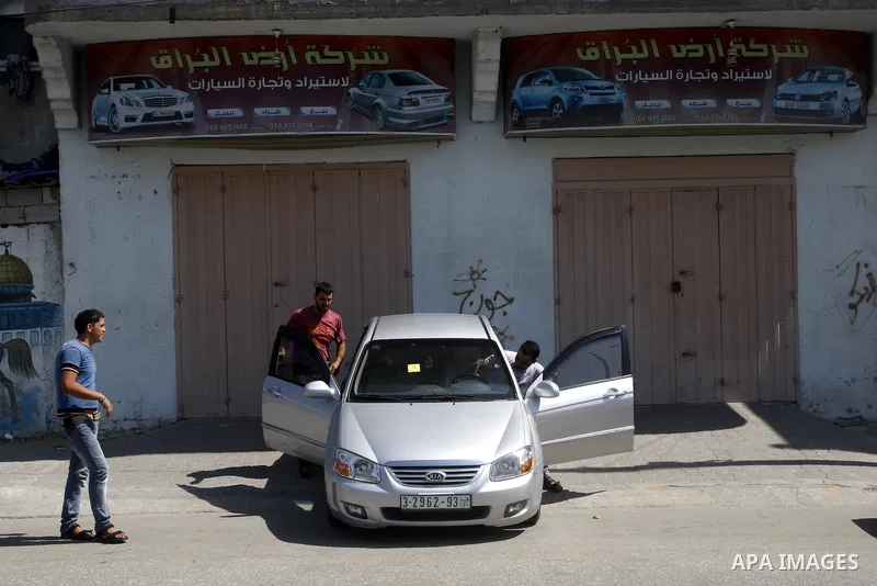 Palestinians watch cars, at a showroom in Gaza City on Sep. 7, 2011. while Israel stop to enter cars into Gaza Strip again after it allowed to enter them as a part of a new strategy to increase Gaza blockade. Photo by Ma...