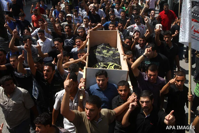 Palestinian mourners carry the body of Remah al-Hasani, a member of its military wing, the Al-Quds Brigades, during his funeral in Gaza city on Sep. 8, 2011. He was killed as he was driving in the central Deir al-Balah d...