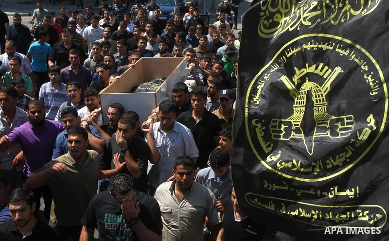 Palestinian mourners carry the body of Remah al-Hasani, a member of its military wing, the Al-Quds Brigades, during his funeral in Gaza city on Sep. 8, 2011. He was killed as he was driving in the central Deir al-Balah d...