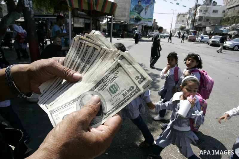 A Palestinian man exchanges currency, in the in city of Rafah the southern Gaza Strip, the U.S. dollar and shekel in black markets in the Gaza Strip on Sep. 8, 2011. Significant increase to the U.S. dollar $1000 against...