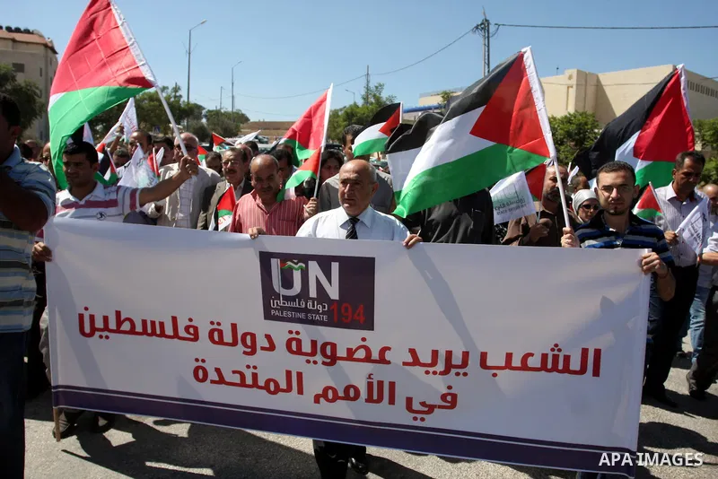 Palestinians hold banners and flags as they march during the launch of a campaign supporting a bid for Palestinian statehood recognition at the U.N, in the West Bank city of Ramallah on Sep. 8, 2011. A member of the camp...