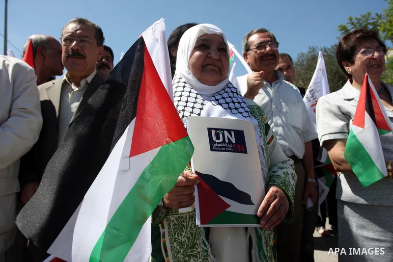 Palestinians hold banners and flags as they march during the launch of a campaign supporting a bid for Palestinian statehood recognition at the U.N, in the West Bank city of Ramallah on Sep. 8, 2011. A member of the camp...