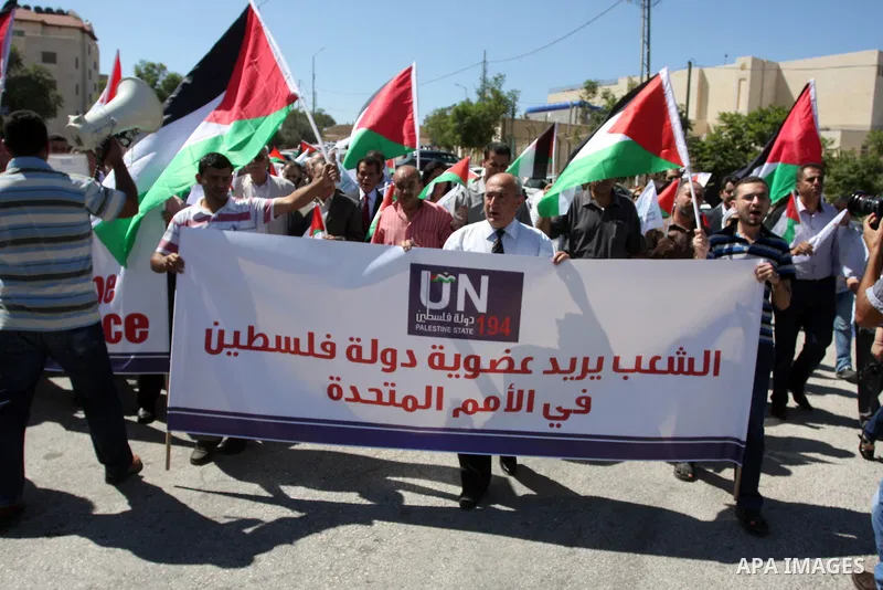 Palestinians hold banners and flags as they march during the launch of a campaign supporting a bid for Palestinian statehood recognition at the U.N, in the West Bank city of Ramallah on Sep. 8, 2011. A member of the camp...