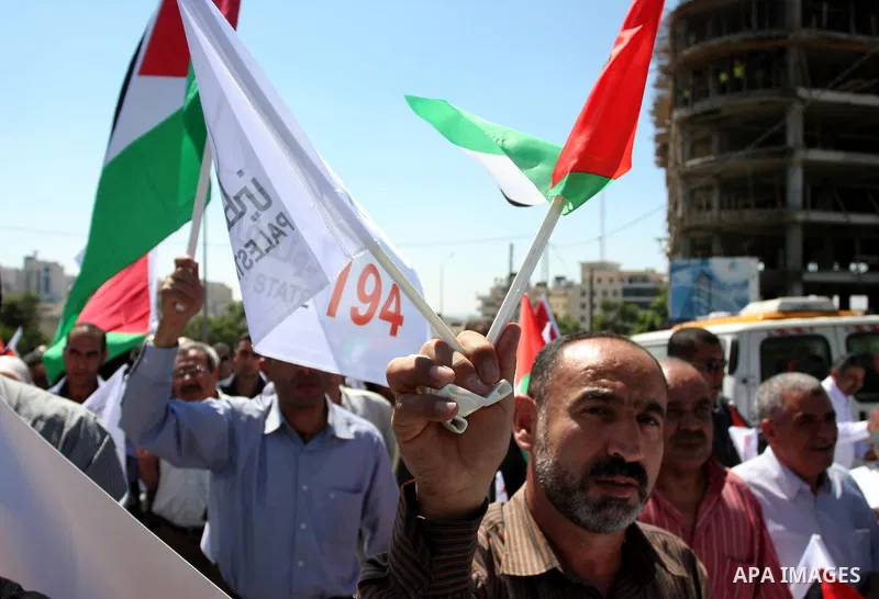 Palestinians hold banners and flags as they march during the launch of a campaign supporting a bid for Palestinian statehood recognition at the U.N, in the West Bank city of Ramallah on Sep. 8, 2011. A member of the camp...
