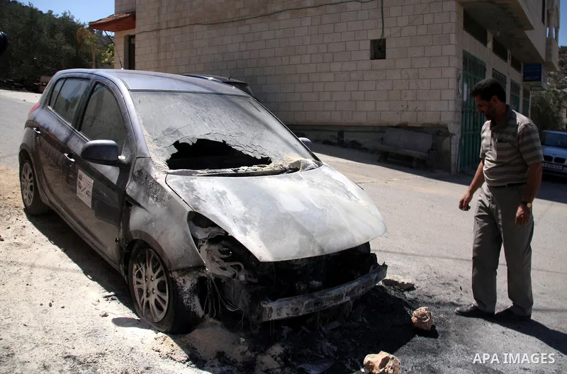 A Palestinian man inspects a car burned by Israeli settlers in Qablan village, northern West Bank city of Nablus, Sept. 8, 2011. Israeli West Bank settlers, meanwhile, came under suspicion Thursday in the latest of a str...