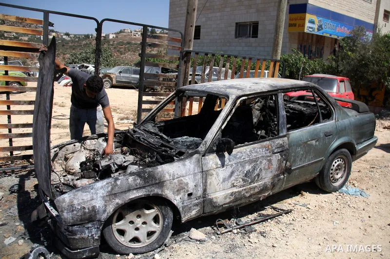 A Palestinian man inspects a car burned by Israeli settlers in Qablan village, northern West Bank city of Nablus, Sept. 8, 2011. Israeli West Bank settlers, meanwhile, came under suspicion Thursday in the latest of a str...