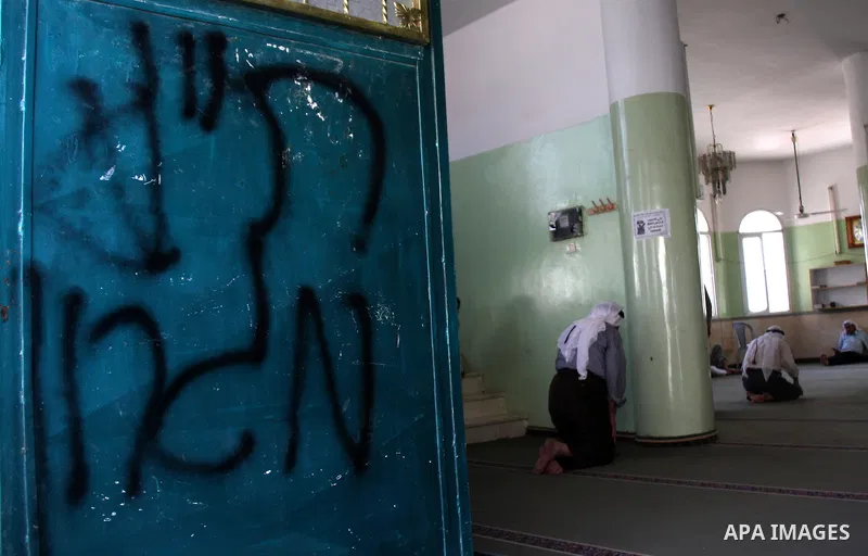 Palestinians attend praying at a mosque whose door was vandalized with the Hebrew words "PR (Price Tag) Migron" in the northern West Bank village of Yatma, Thursday, Sept. 8, 2011. Israeli West Bank settlers, meanwhile,...