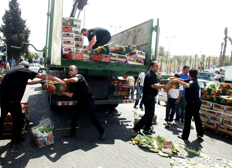Israeli policemen and municipality employees confiscate the Palestinian sellers' vegetables and fruit in Jerusalem's old city on Sep. 9,2011. Photo by Mahfouz Abu Turk