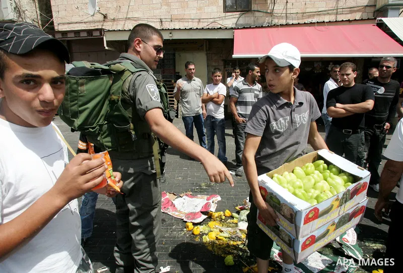 Israeli policemen and municipality employees confiscate the Palestinian sellers' vegetables and fruit in Jerusalem's old city on Sep. 9,2011. Photo by Mahfouz Abu Turk