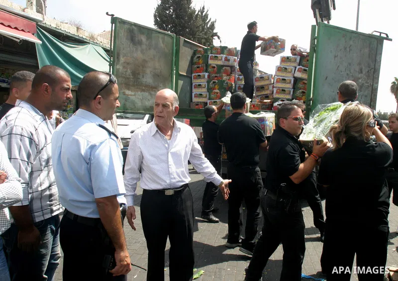 Israeli policemen and municipality employees confiscate the Palestinian sellers' vegetables and fruit in Jerusalem's old city on Sep. 9,2011. Photo by Mahfouz Abu Turk
