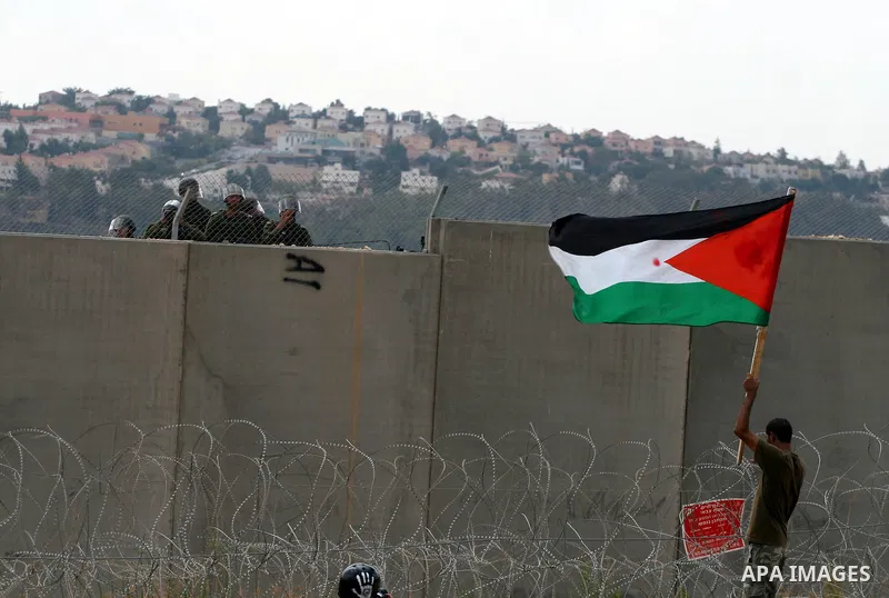 A Palestinian man waves a flag during a demonstration in the West Bank town of Bilin, near Ramallah, Friday, Sept. 9, 2011. The Palestinians have launched a campaign to rally support for U.N. recognition as an independen...
