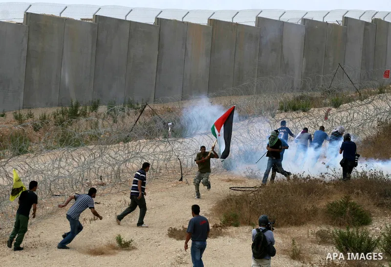 Palestinians run for cover from tear gas fired by Israeli soldiers during a demonstration in the West Bank town of Bilin, near Ramallah, Friday, Sept. 9, 2011. The Palestinians have launched a campaign to rally support f...