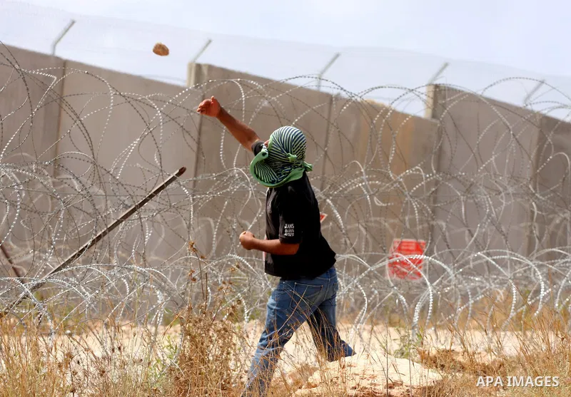 A Palestinian man hurls stones toward Israeli soldiers during a demonstration in the West Bank town of Bilin, near Ramallah, Friday, Sept. 9, 2011. The Palestinians have launched a campaign to rally support for U.N. reco...