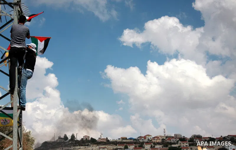 Palestinians wave their national flag during the weekly protest against the settlement of Qadomim, near the village of Kofr Qadom, west of Nablus City, in the Israeli-occupied West Bank on 09 September 2011. Photo by Wag...