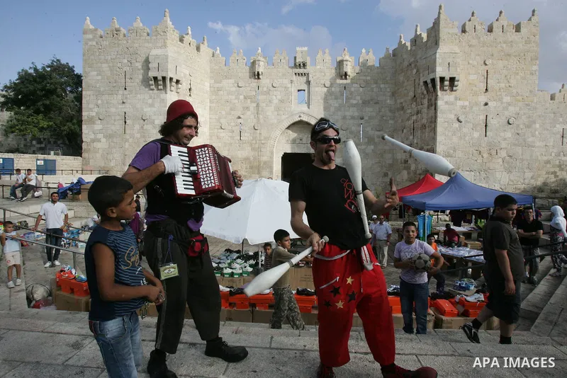 Performers with the international "Festiclown" group entertain passers-by outside Damascus Gate in Jerusalem's Old City on September 9, 2011, as part of the first international clown festival in the Palestinian territori...