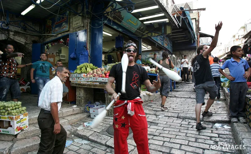 Performers with the international "Festiclown" group entertain passers-by outside Damascus Gate in Jerusalem's Old City on September 9, 2011, as part of the first international clown festival in the Palestinian territori...