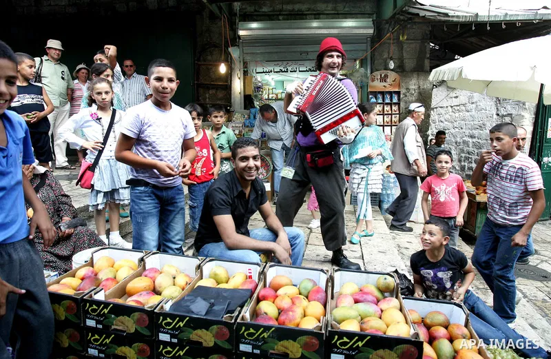 Performers with the international "Festiclown" group entertain passers-by outside Damascus Gate in Jerusalem's Old City on September 9, 2011, as part of the first international clown festival in the Palestinian territori...