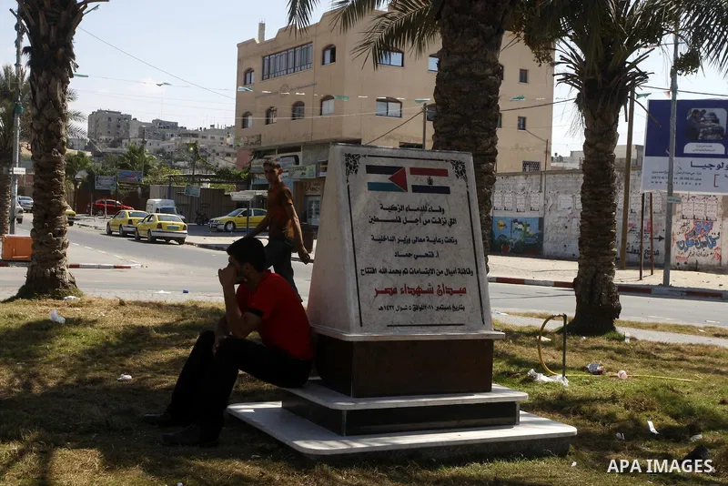 A Palestinian man sits on the memorial site in memory of the Egyptian policemen who were killed by the Israeli army in Gaza city on Sep.10, 2011. While the Egyptians held a series of protests in front of the Israeli emba...