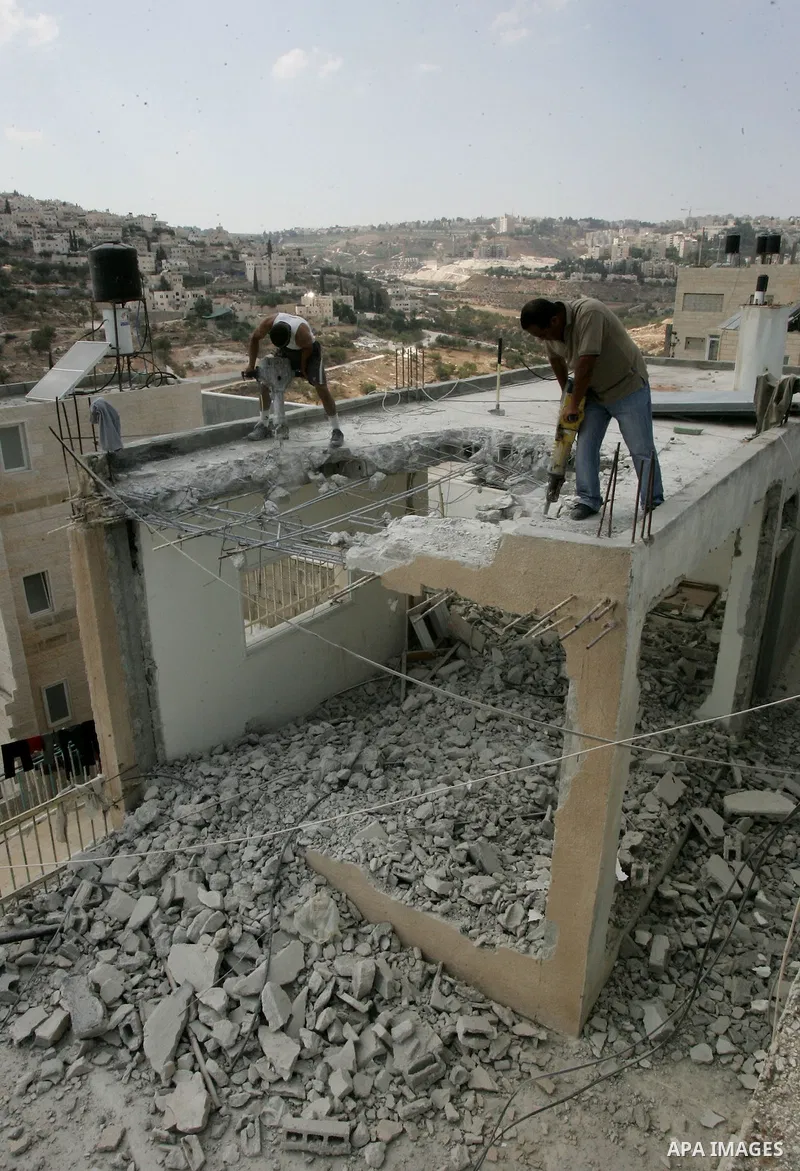 Palestinian Jerusalem resident Adnan Taha destroys his own home with a fellow Palestinian in Arab east Jerusalem on September 11, 2011, in implementation of an Israeli court order which ruled that the house was built wit...