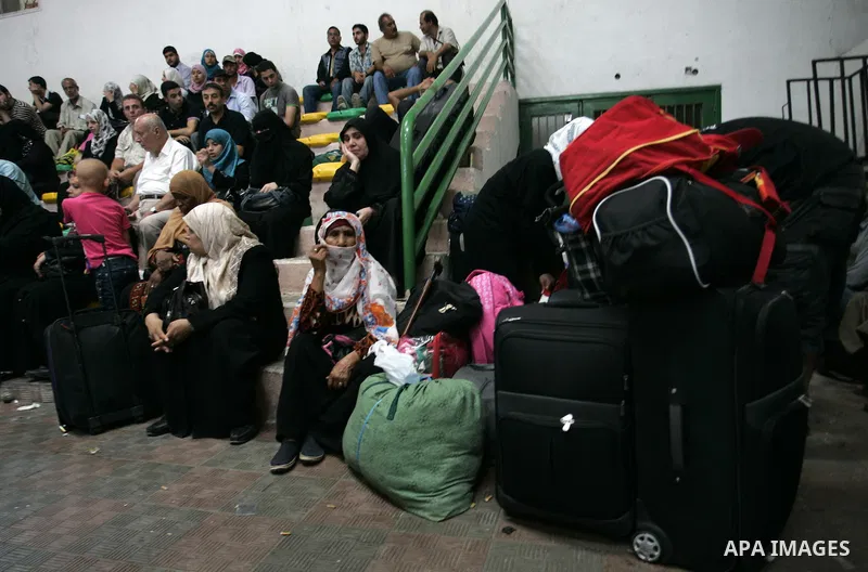 Palestinians sit near their luggage as they wait to cross into Egypt through the Rafah border crossing in the southern Gaza Strip on Sep 12, 2011. Photo by Abed Rahim Khatib