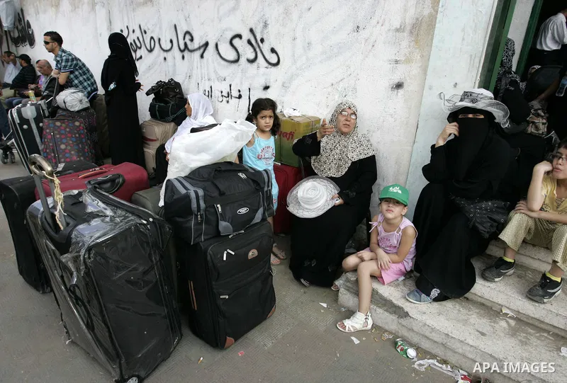 Palestinians sit near their luggage as they wait to cross into Egypt through the Rafah border crossing in the southern Gaza Strip on Sep 12, 2011. Photo by Abed Rahim Khatib
