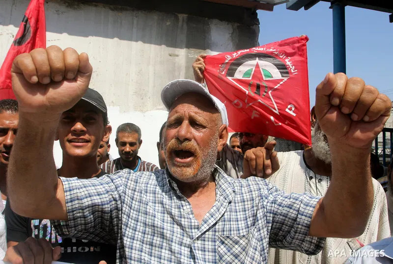 Palestinians shout slogans during a rally supporting a bid for Palestinian statehood recognition at the U.N., at a United Nations Relief and Works Agency (UNRWA) food distribution center in Rafah in the southern Gaza Str...
