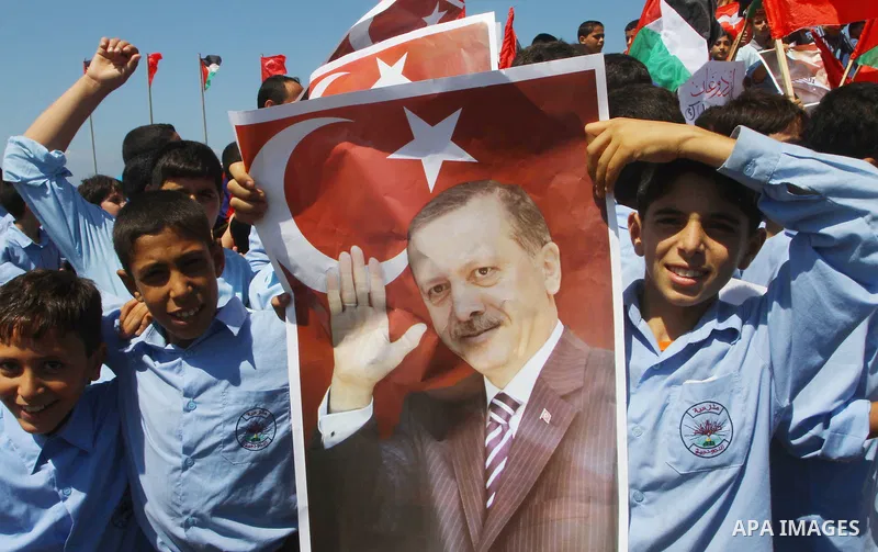 Palestinian students hold the pictures of Turkish Prime Minister Recep Tayyip Erdogan and the Turkish and Palestinian flags during rally beckoning him to visit the Gaza Strip at the port in Gaza City on Sep. 13, 2011. Er...