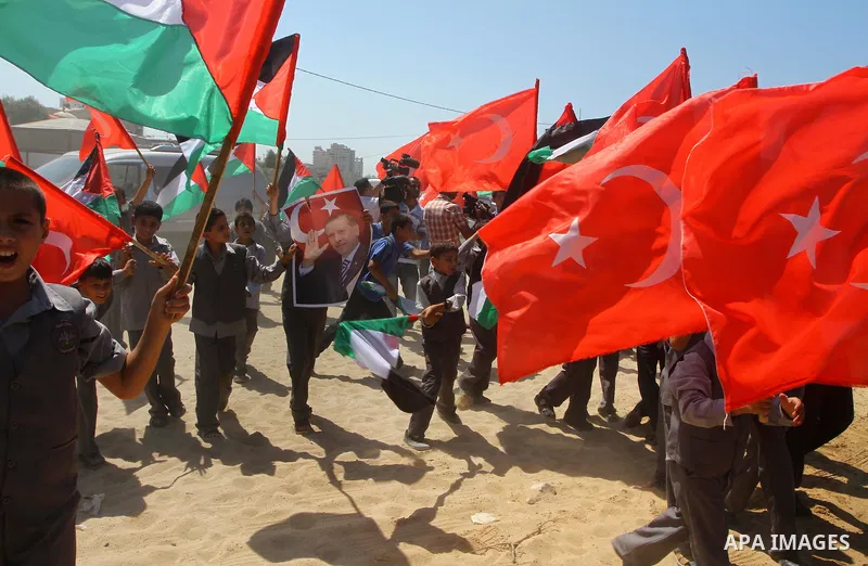 Palestinian students hold the pictures of Turkish Prime Minister Recep Tayyip Erdogan and the Turkish and Palestinian flags during rally beckoning him to visit the Gaza Strip at the port in Gaza City on Sep. 13, 2011. Er...
