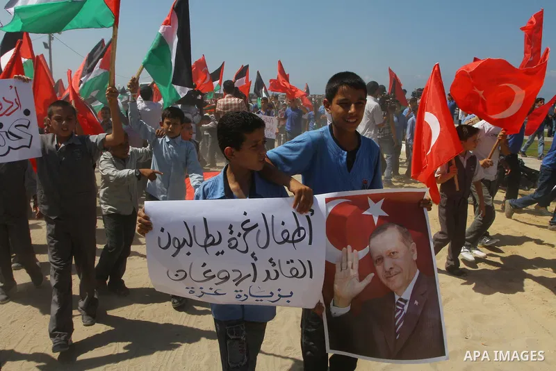 Palestinian students hold the pictures of Turkish Prime Minister Recep Tayyip Erdogan and the Turkish and Palestinian flags during rally beckoning him to visit the Gaza Strip at the port in Gaza City on Sep. 13, 2011. Er...