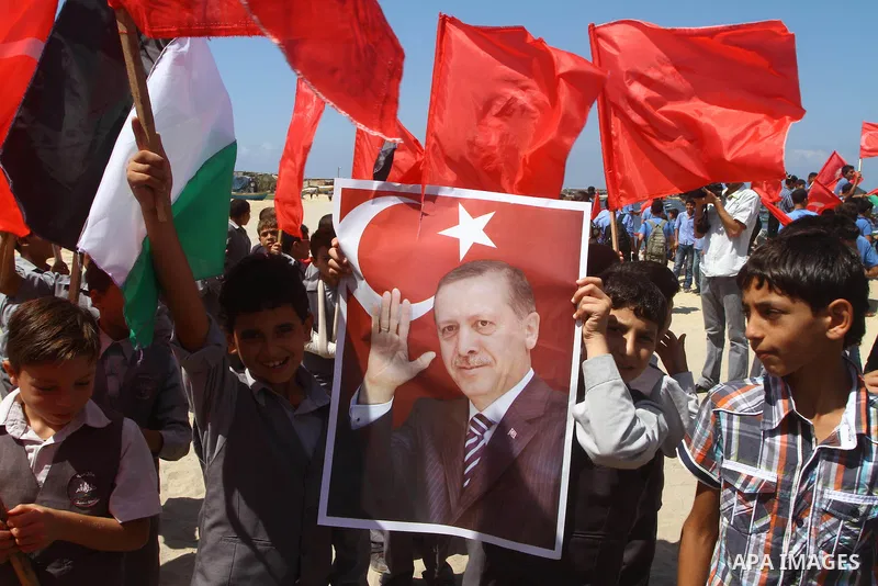 Palestinian students hold the pictures of Turkish Prime Minister Recep Tayyip Erdogan and the Turkish and Palestinian flags during rally beckoning him to visit the Gaza Strip at the port in Gaza City on Sep. 13, 2011. Er...
