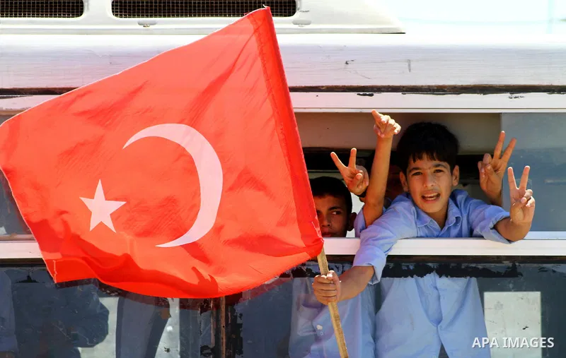 Palestinian students hold the pictures of Turkish Prime Minister Recep Tayyip Erdogan and the Turkish and Palestinian flags during rally beckoning him to visit the Gaza Strip at the port in Gaza City on Sep. 13, 2011. Er...