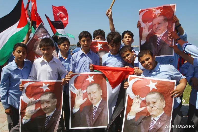 Palestinian students hold the pictures of Turkish Prime Minister Recep Tayyip Erdogan and the Turkish and Palestinian flags during rally beckoning him to visit the Gaza Strip at the port in Gaza City on Sep. 13, 2011. Er...